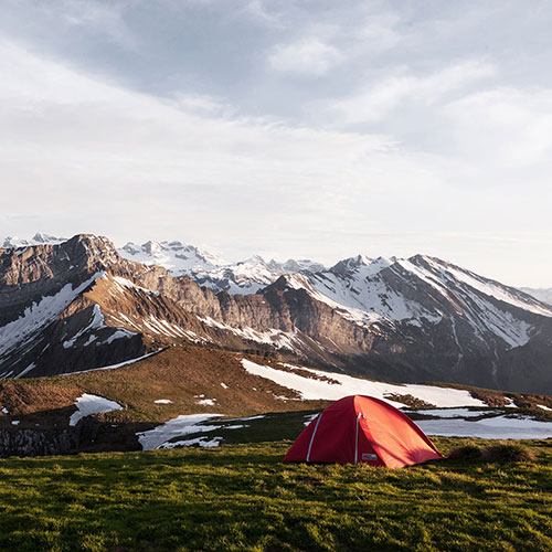 Tent camping near snow-covered mountains